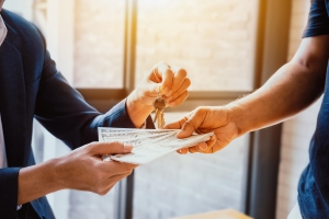 Photo of landlord and tenant exchanging money and keys